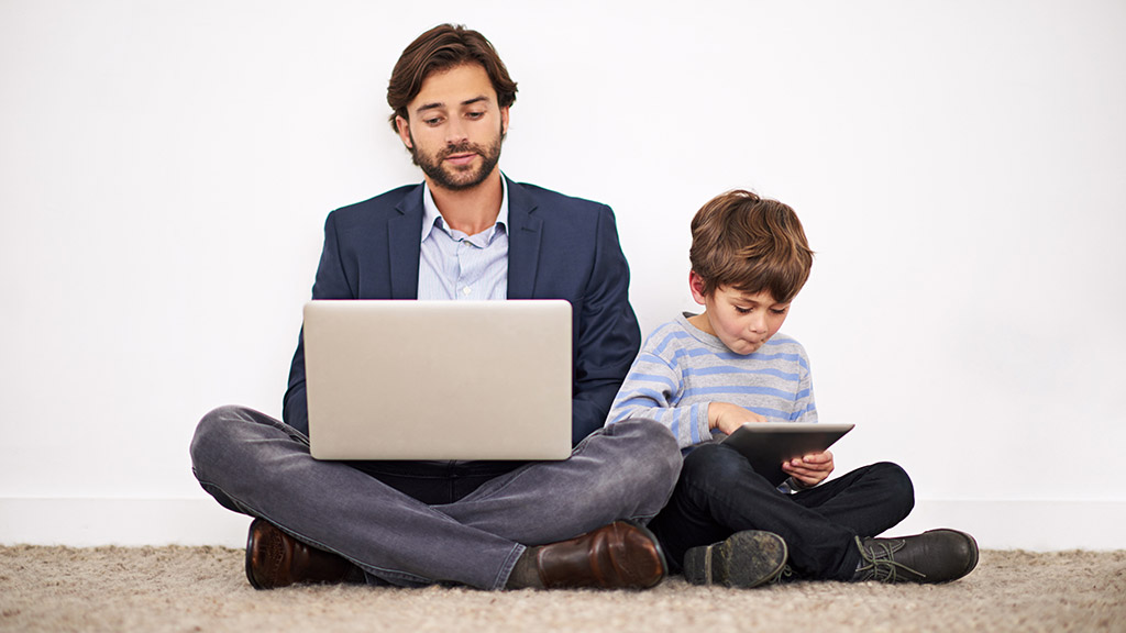 Padre e figlio che usano dispositivi elettronici