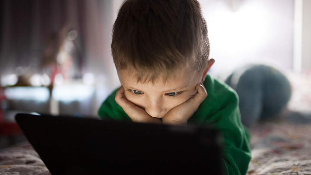 Bambino alla ricerca dell'autonomia digitale davanti al tablet