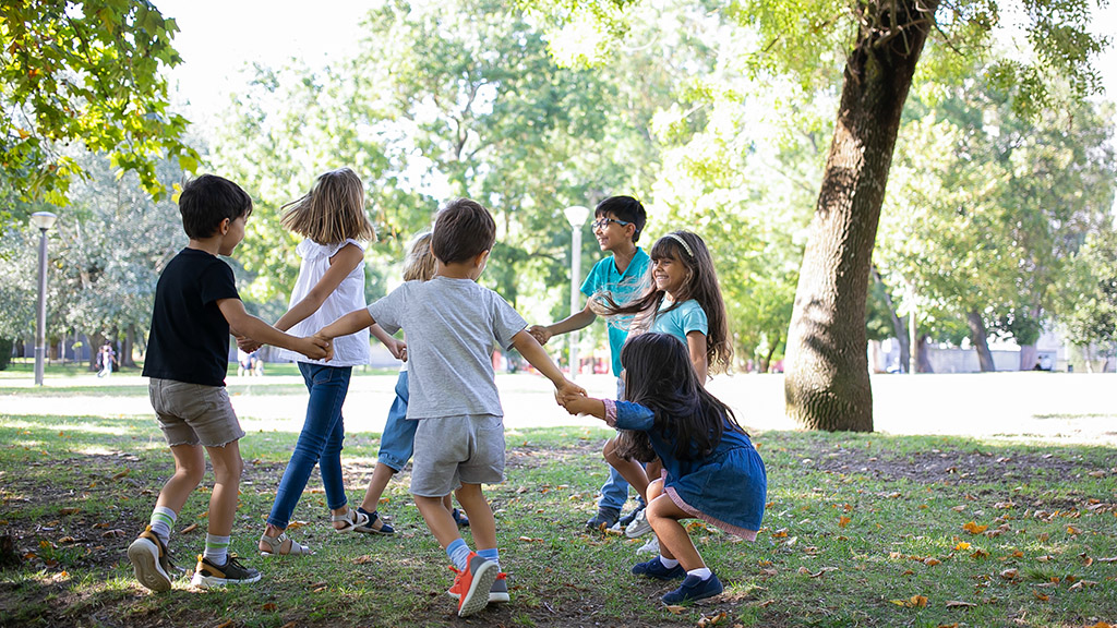 Bambini allegri al parco che giocano all'aria aperta