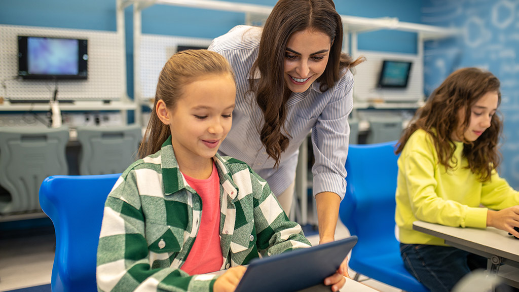 Scuola e tecnologia. Insegnante e alunni in aula di informatica